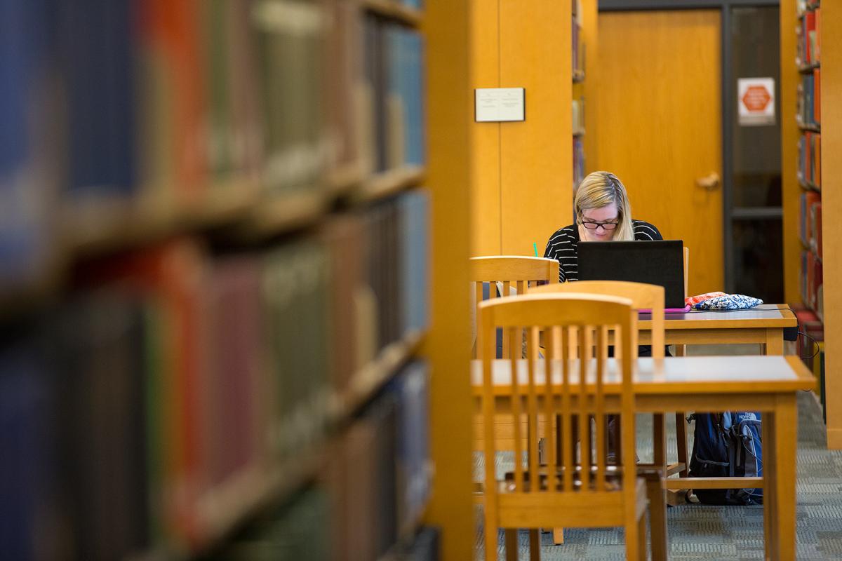 Student writing in library